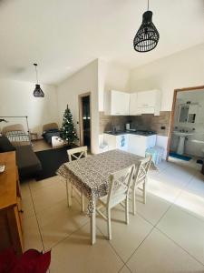 una cucina e un soggiorno con tavolo e sedie di Casa Lele a Gela
