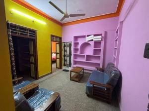 ein Wohnzimmer mit lila und gelben Wänden in der Unterkunft Siva Sandhy Guset House in Tiruvannāmalai + 6 Fotos