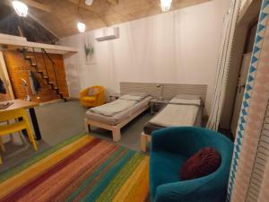 a room with two beds and a chair and a table at Wolna Chwila in Maków