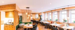 a restaurant with tables and chairs and windows at Aparthotel Sonnenburg in Schluchsee