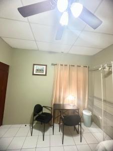 Habitación León Queen Deluxe في ليون: غرفة طعام مع مروحة سقف وطاولة وكراسي