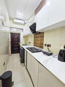a kitchen with white counters and a stove top oven at 3-Bedroom fully serviced terrace in Orchid, Lekki Sig4 in Lekki