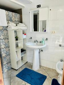 un bagno bianco con lavandino e doccia di Casa Lele a Gela