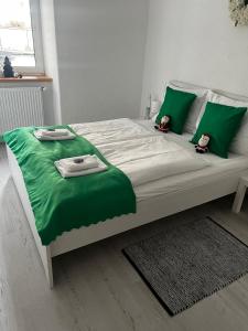 a large bed with green sheets and two dolls on it at Apartment MICHAELA in Spital am Pyhrn +27 photos