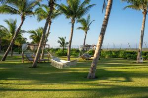 um parque com palmeiras e um baloiço em Hoi An Beachfront 5 star Resort & Apartment em Dien Ban