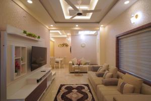 a living room with a couch and a tv at Changanassery in Changanācheri