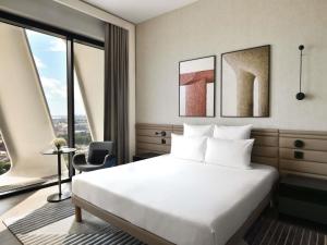 a hotel room with a bed and a large window at Novotel Abidjan Marcory in Abidjan +135 photos