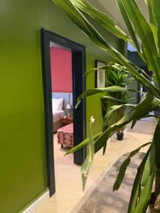 a green room with a mirror and a plant at The Libreville in Abuja