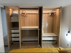 a walk in closet with wooden cabinets and hangers at Superbe 2 pièces refait à neuf idéalement situé in Meung-sur-Loire
