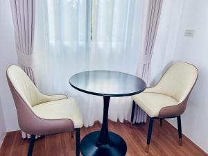 two chairs and a glass table in a room at Sarona House 4 in Ban Thalat Choeng Thale