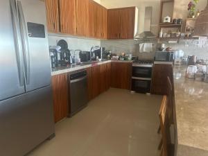 a kitchen with wooden cabinets and a stainless steel refrigerator at Refúgio prea in Cruz