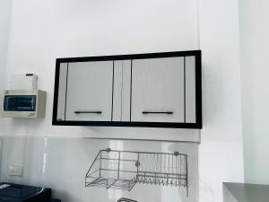 a kitchen with white cabinets and a microwave at Sarona House 4 in Ban Thalat Choeng Thale +16 photos