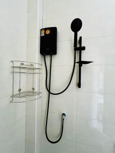 una doccia con un telefono e una croce sul muro di Sarona House 4 a Ban Thalat Choeng Thale