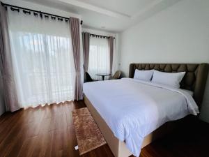 una camera da letto con un letto grande e una grande finestra di Sarona House 4 a Ban Thalat Choeng Thale