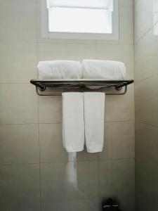 un bagno con asciugamani bianchi su una mensola di Sarona House 4 a Ban Thalat Choeng Thale Altre 16 foto