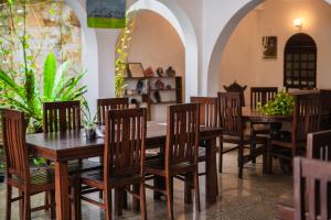 a dining room with wooden tables and chairs at Sunset Fort Galle in Galle