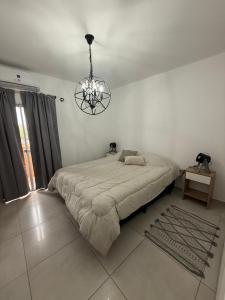 ein Schlafzimmer mit einem großen Bett und einem Kronleuchter in der Unterkunft Liberty - San Juan in Rivadavia