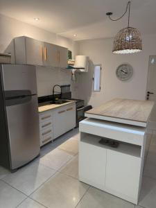 eine Küche mit einem Edelstahlkühlschrank und weißen Schränken in der Unterkunft Liberty - San Juan in Rivadavia