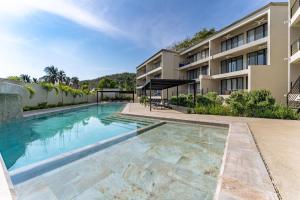 an image of a swimming pool in front of a building at 3077 - Solana B203 in Santa Cruz Huatulco