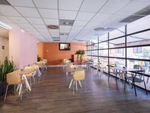 a dining room with tables and chairs and windows at B&B Hotel Roma Tuscolana San Giovanni in Rome +33 photos