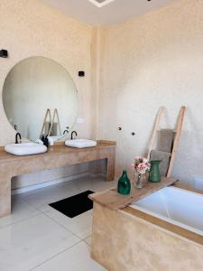 Un baño con dos lavabos y un espejo grande. en Villa Palms Marrakech, en Marrakech
