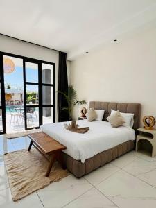 Un dormitorio con una cama grande y una mesa. en Villa Palms Marrakech, en Marrakech