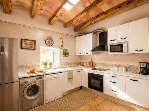 a kitchen with white cabinets and a dishwasher at Villa Can Mestreso Suite Ibiza in Sant Joan de Labritja