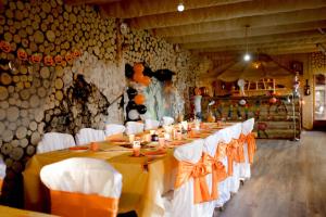 PetrilaPensiunea Gui的配有长桌子和白色椅子的房间