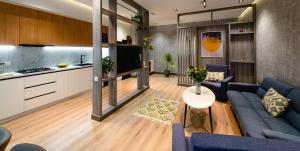 Una sala de estar con un sofá azul y una cocina. en City Deluxe Apartments, en Tashkent 46 fotos más