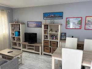 a living room with a table and a television at Casa Nueva in Las Palmas de Gran Canaria