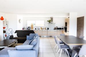 a living room and kitchen with a table and chairs at villa boileau in Sérignan