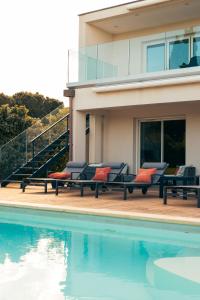 una casa con sedie accanto a una piscina di villa boileau a Sérignan