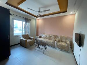 a living room with a couch and a tv at Sherazi Arcade in Islamabad