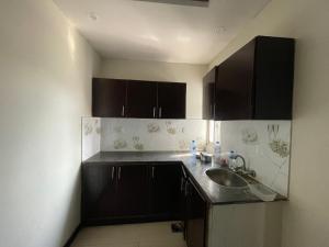 a kitchen with black cabinets and a sink at Sherazi Arcade in Islamabad