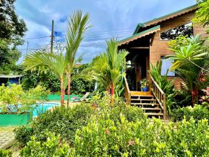 a house with a pool in front of it at Finca Los Mangos in Manuel Antonio