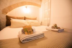 a bedroom with a bed with towels on it at Suite Pietra Bianca - Relax & SPA in Martina Franca