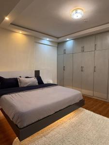 a bedroom with a bed with white cabinets and a rug at HD Residential Apartment , Bole Dembel in Addis Ababa