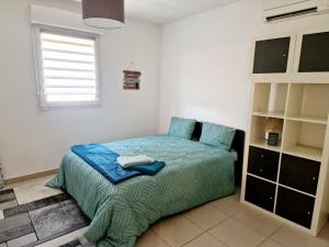 a bedroom with a bed with blue sheets and a window at Villa Cosy T5, Calme avec Jacuzzi XL in Nîmes