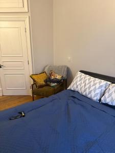 a bedroom with a blue bed and a chair at PICCADILLY Private room and bathroom in Manchester