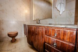 a bathroom with a wooden tub and a toilet at Hostel Wafeh Fleming in Belo Horizonte
