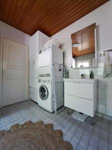 una cucina bianca con lavatrice e asciugatrice di Villa Hammar a Sulkava