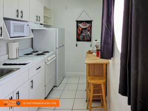 a kitchen with white appliances and a wooden table at Amazing Studio Steps Away From The Atlantic Ocean! in Daytona Beach
