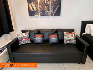 a black leather couch with pillows on it at Amazing Studio Steps Away From The Atlantic Ocean! in Daytona Beach