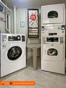 a laundry room with two washing machines and a table at Amazing Studio Steps Away From The Atlantic Ocean! in Daytona Beach