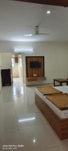 a bedroom with a bed and a flat screen tv at Sgr Luxury Homes in Kammasandra