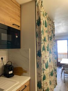 een keuken met een gordijn met kerstbomen erop bij Central Val Thorens - 4 pers - Newly renovated in Val Thorens