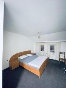 a bedroom with a large bed and a chandelier at Hostel 8 in Pristina