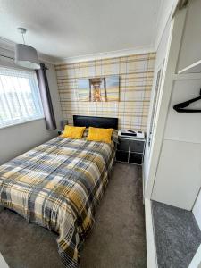 a bedroom with a bed with yellow pillows at The Three bs in Scratby +25 photos