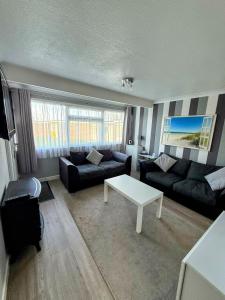a living room with a couch and a table at The Three bs in Scratby