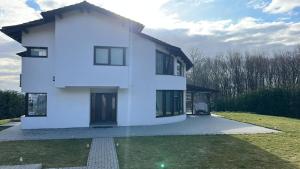 a white house with a driveway in front of it at Vila Liana in Stana